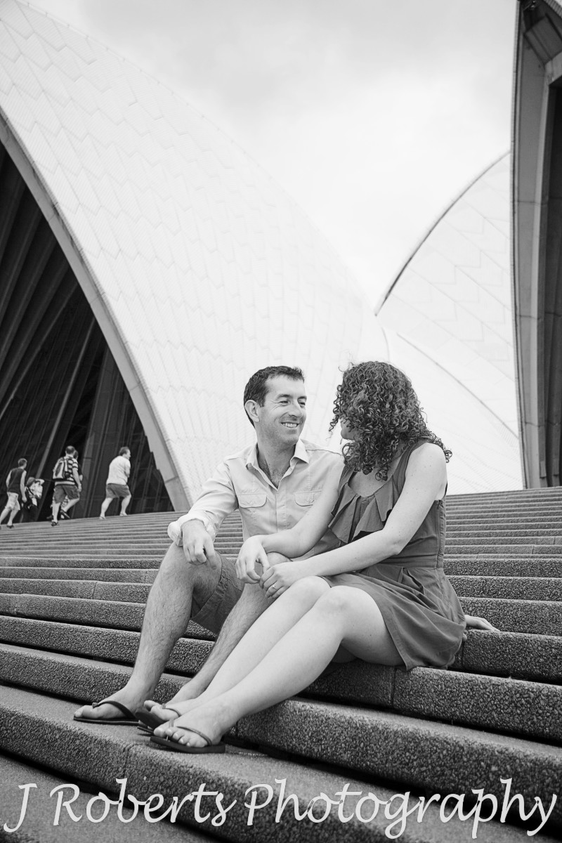 Engaged couple sitting on the Sydney Opera House steps - engagement photography sydney